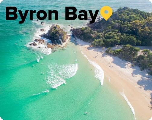  Cape Byron with turquoise waves washin up on white sand beach Byron Bay
